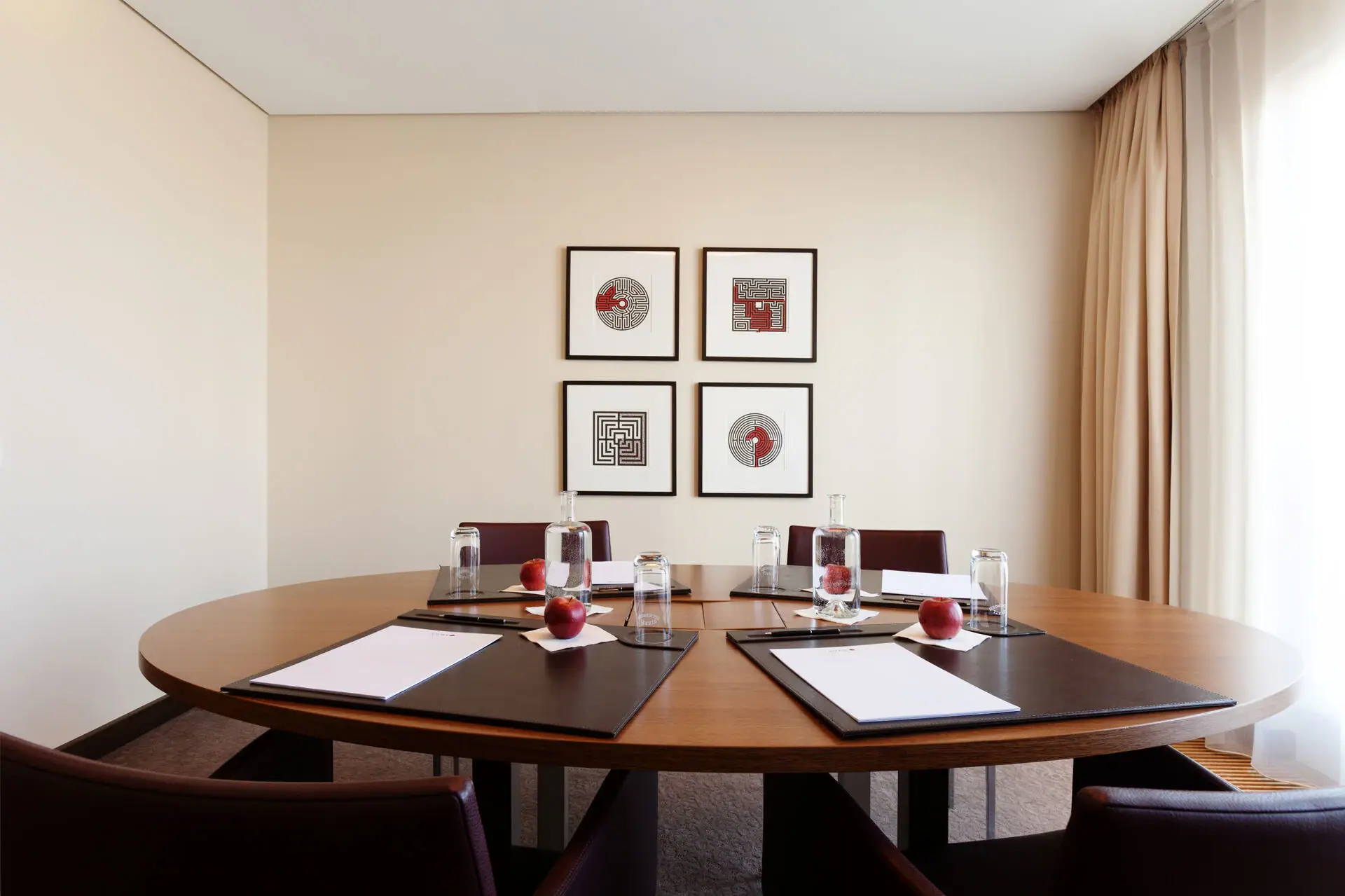 Meetingsraum In einem kleinen Meetingraum steht ein ovaler Tisch mit 4 Sesseln.