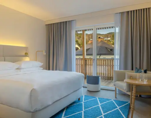 A stylish bedroom featuring a neatly made bed, a chair, and a small table.