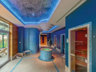 Interior with majorelle blue wall and round fountain.