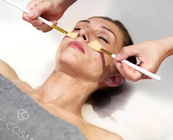 A woman receiving a facial mask indoors.