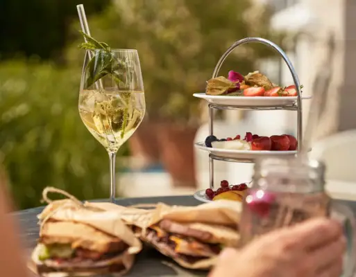 A plate of food on a table with a wine glass nearby.
