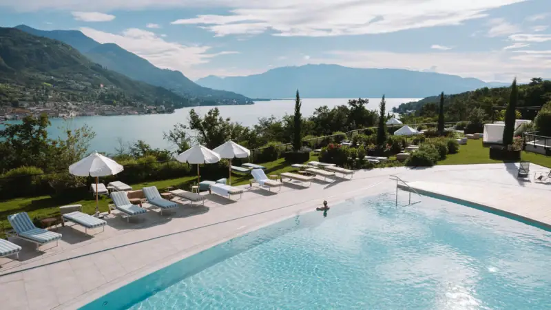 Ein Pool mit Liegestühlen und Sonnenschirmen am Wasser.