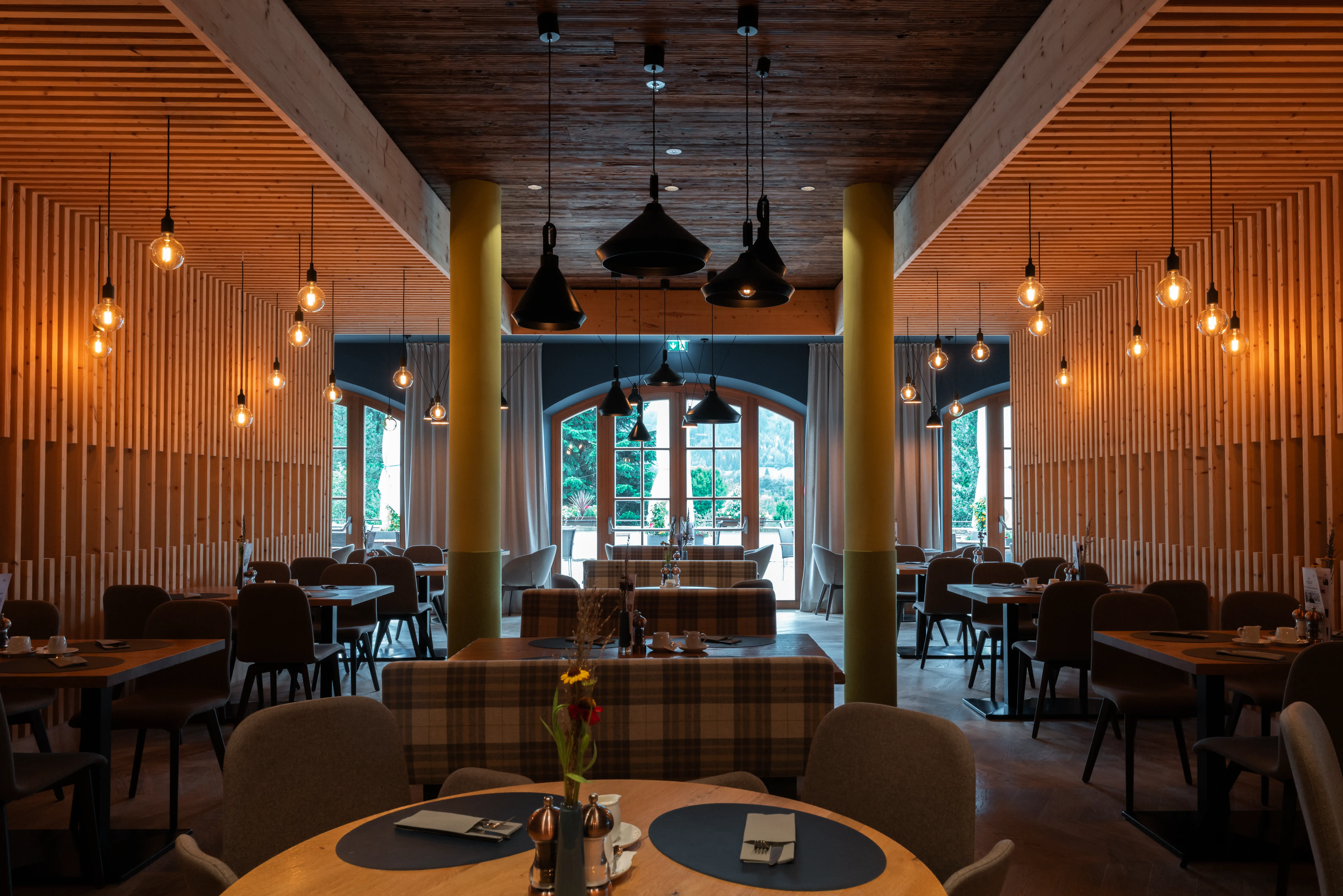 Großer Raum mit Tischen und Stühlen unterschiedlich angeordent, gedeckt für das Frühstück