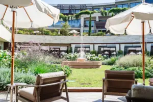 Chairs and parasols in a courtyard with a fountain in the background