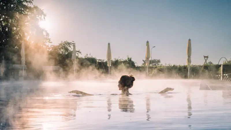 Eine Frau in einem Pool mit einer heißen Quelle.