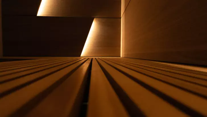 A close-up picture of the wooden sauna in warm lighting. 