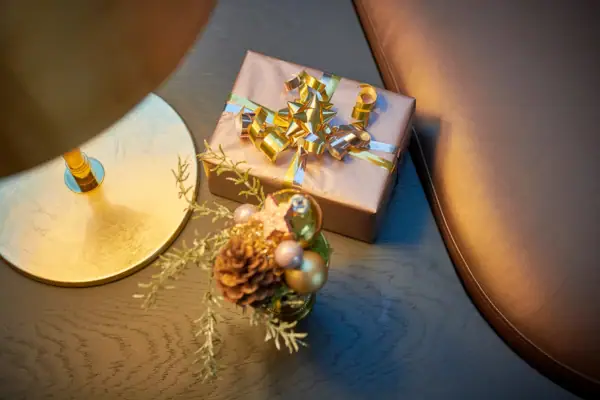 Geschenkbox mit Schleife und Tannenzapfen auf einem Tisch