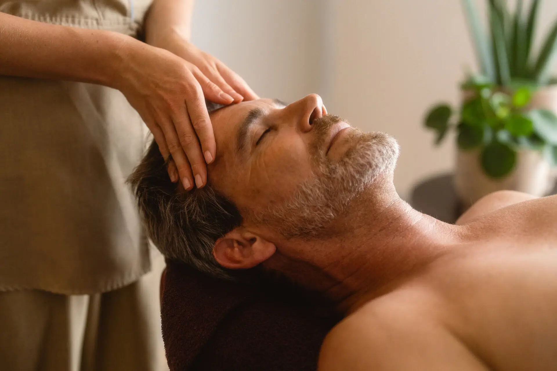 A man receiving a massage indoors.