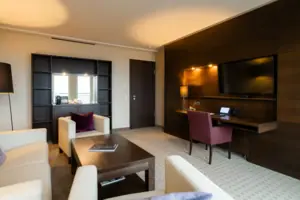 A hotel room with television and table.