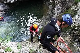Eine Gruppe von Menschen klettert eine Felswand hoch.