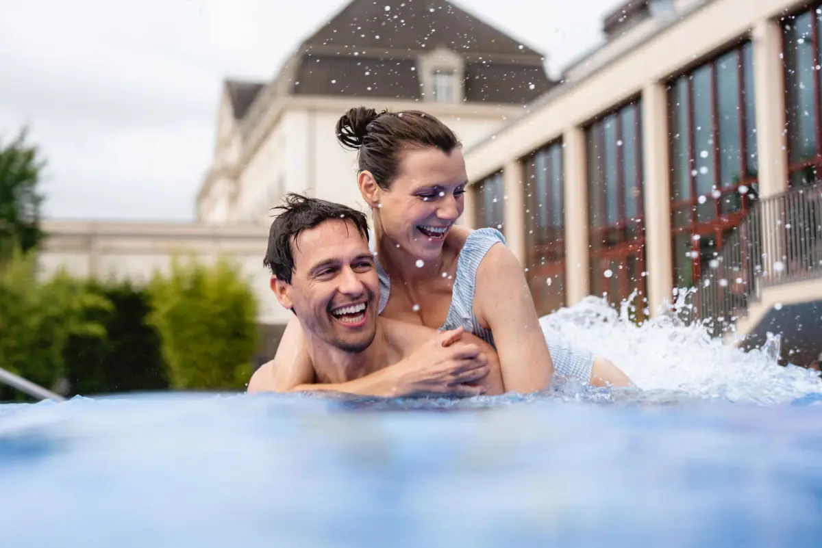 A couple in the pool at the A-ROSA Hotel Travemünde A man is carrying a woman in a swimming pool.