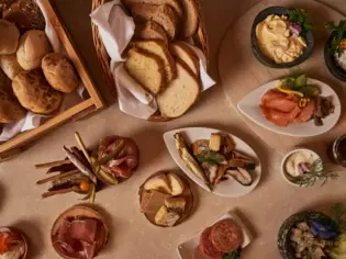 Table with a selection of different dishes, including fast food, snacks and vegetables.