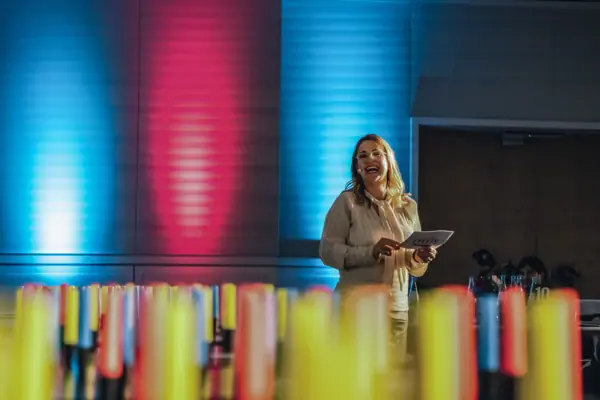 Woman laughing in a room with many colourful objects.