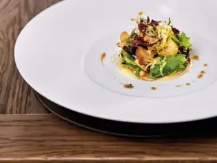 A plate of food on a table, artfully garnished.