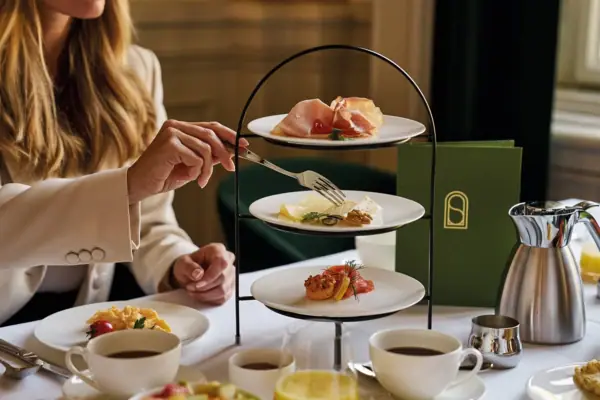A woman holds a fork over plates of food.