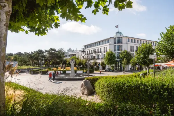 White building in between green surroundings.