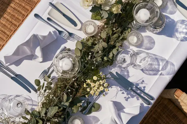 A table decorated with flowers and candles in vases.