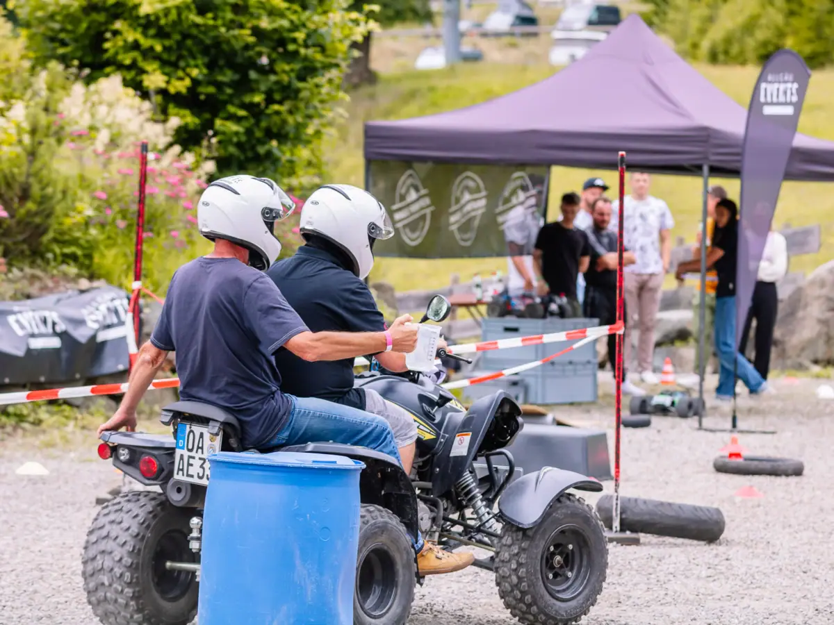 A couple on a quad bike outdoors.