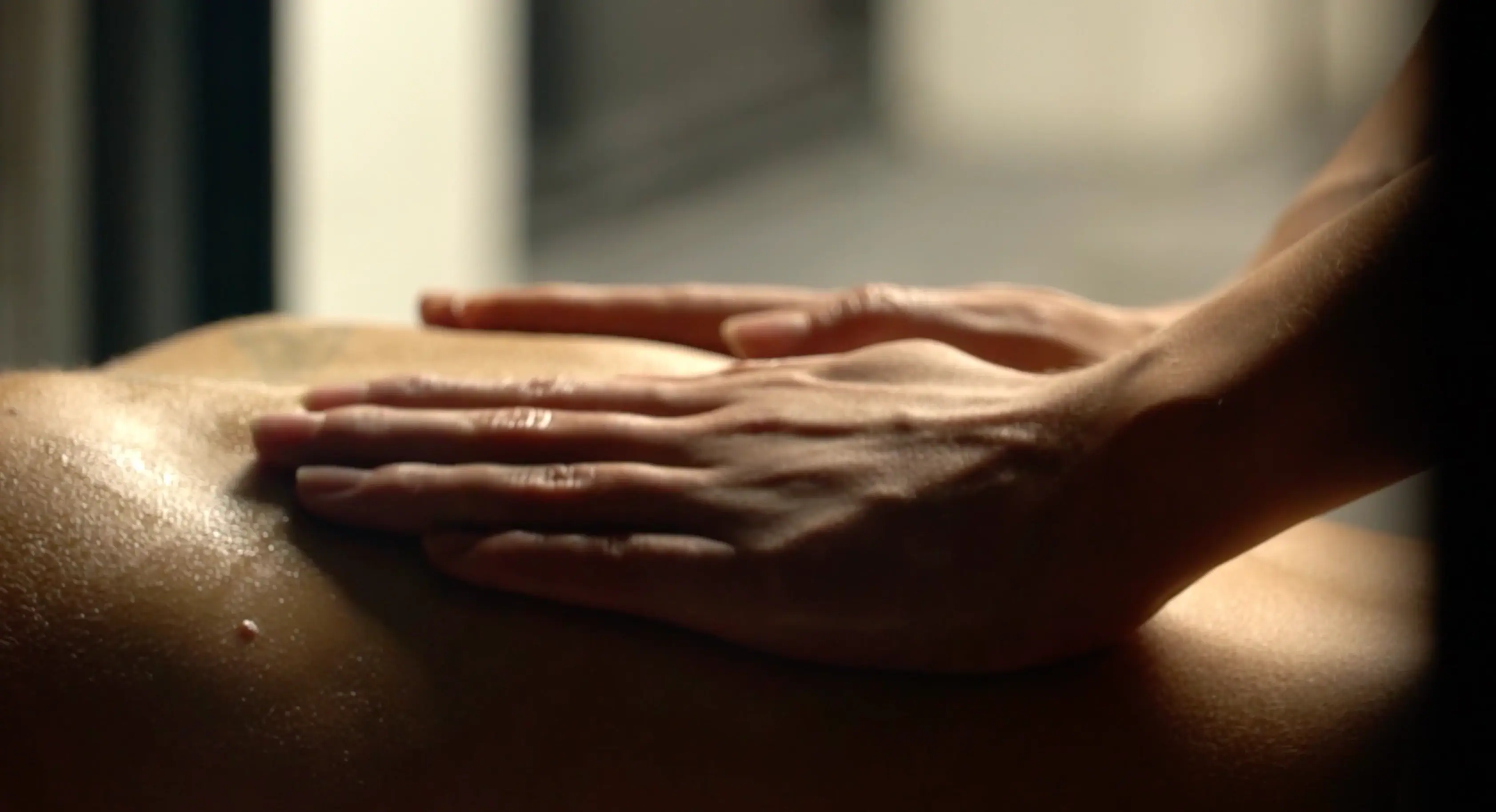 A person's hand gently resting on another person's back.