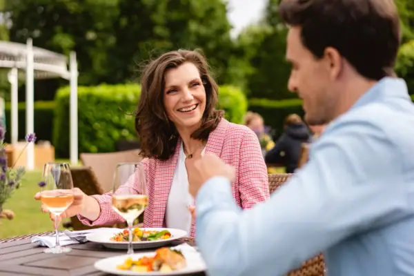 Ein Mann und eine Frau sitzen an einem Tisch mit Essen und Getränken.