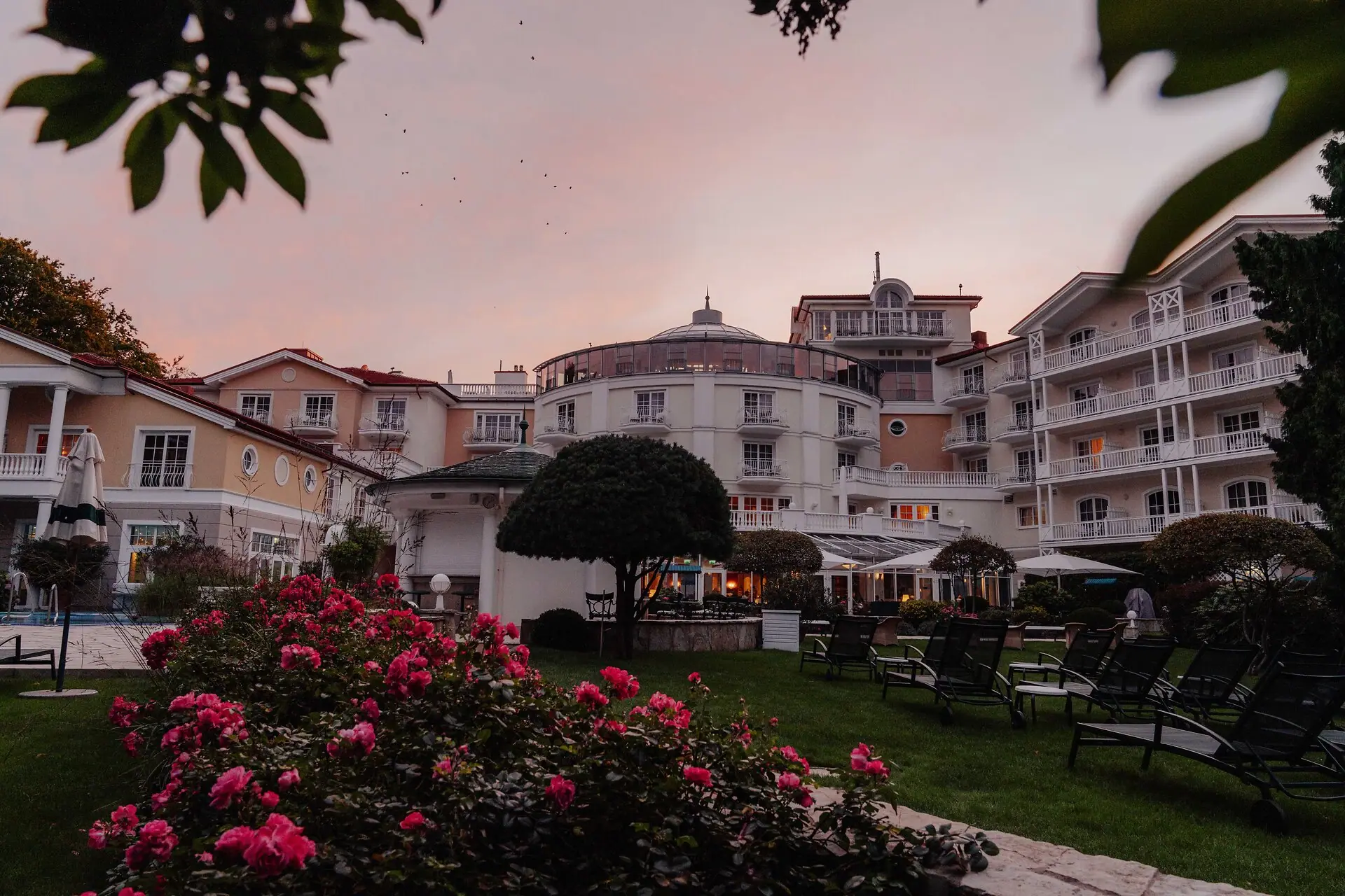 Rasen mit Stühlen und Blumen vor einem Gebäude
