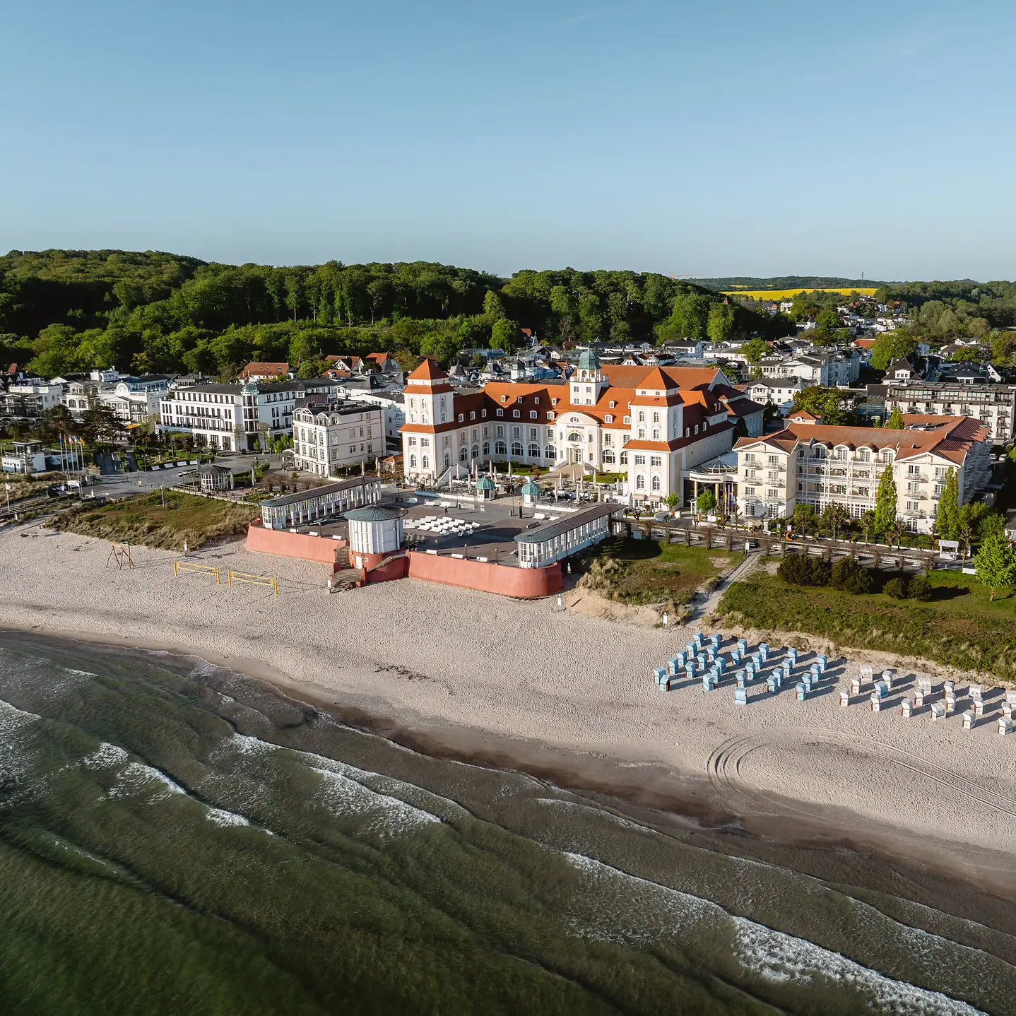 A large building on a beach with chairs under a clear sky.