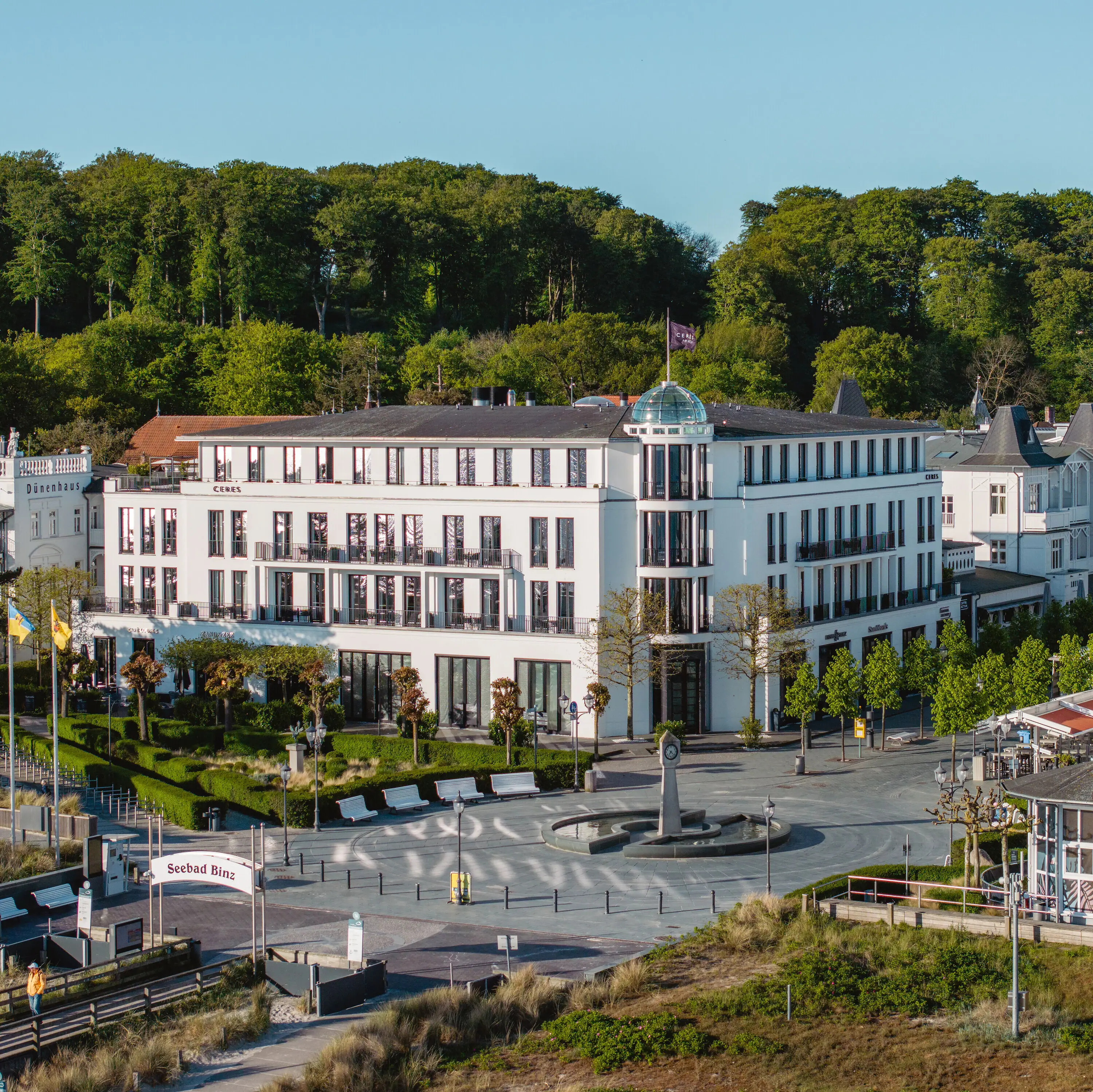 White building with trees in the background.