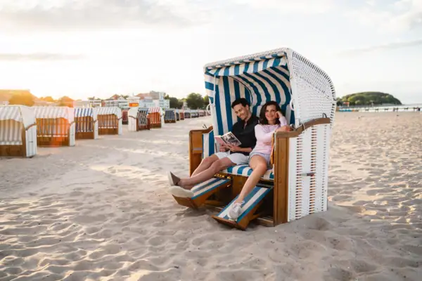 Couple relaxing in a beach chair on the sandy beach at A-ROSA Sylt.
