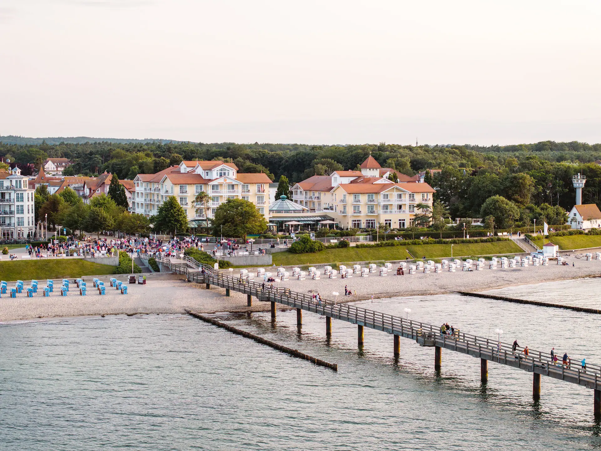 Ein Pier mit Menschen darauf und Gebäuden am Ufer.