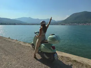 Woman on a scooter on the shore of Lake Garda.