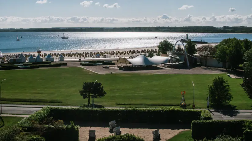 A view of the hotel's outdoor area, a green meadow and the neighbouring beach. 