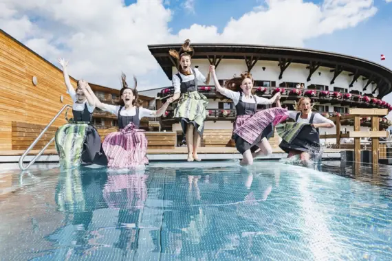 Group of women jumping into a pool.