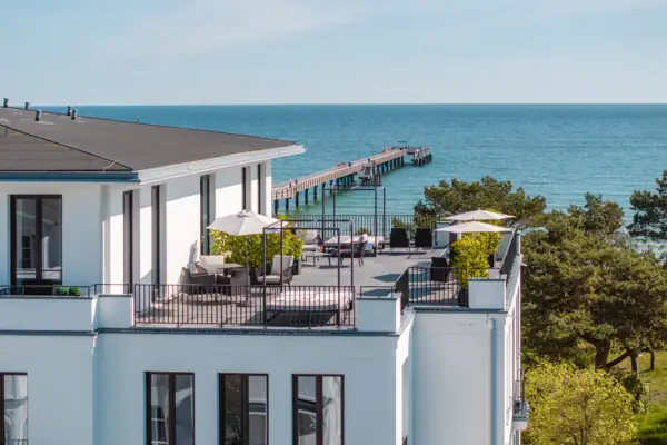 Ceres by the sea A building with a footbridge and trees.