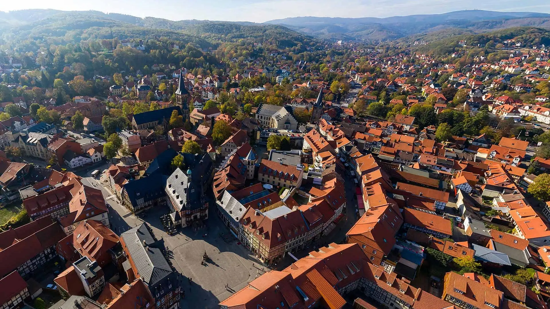 Drohnenaufnahme Wernigerode Luftaufnahme einer Stadt mit Häusern, Bäumen und Himmel im Hintergrund.