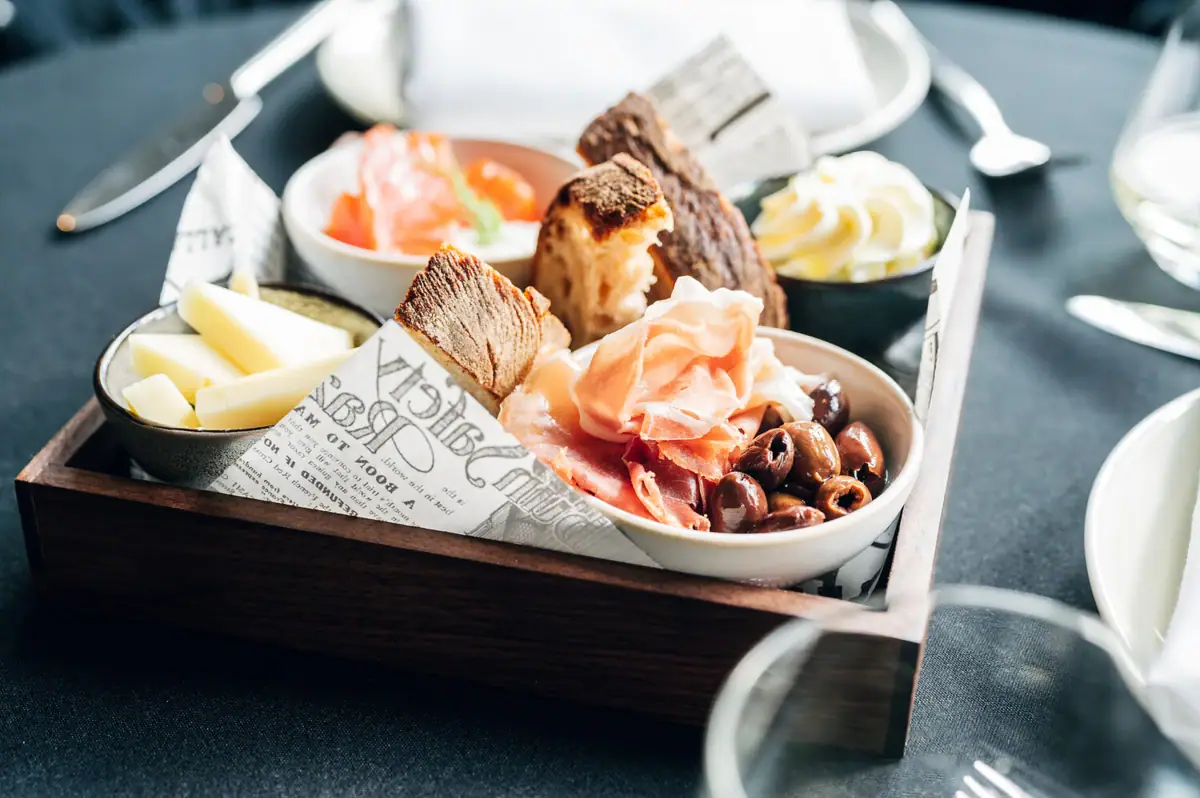 A tray of assorted food on a table with tableware.