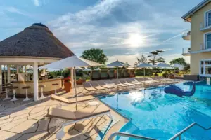 A pool with sun loungers and parasols.