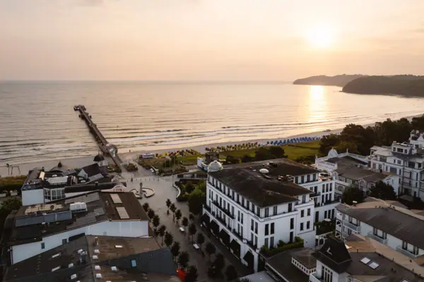 A beach with buildings and a pier in the background.