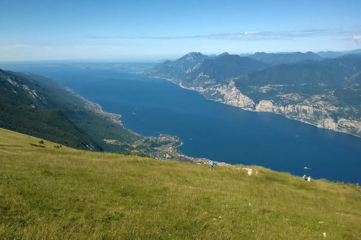 View from Monte Baldo A person is standing on a mountain, looking out over a lake.