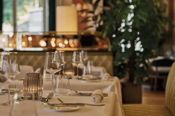 A close-up of a laid table with a white tablecloth in a restaurant.