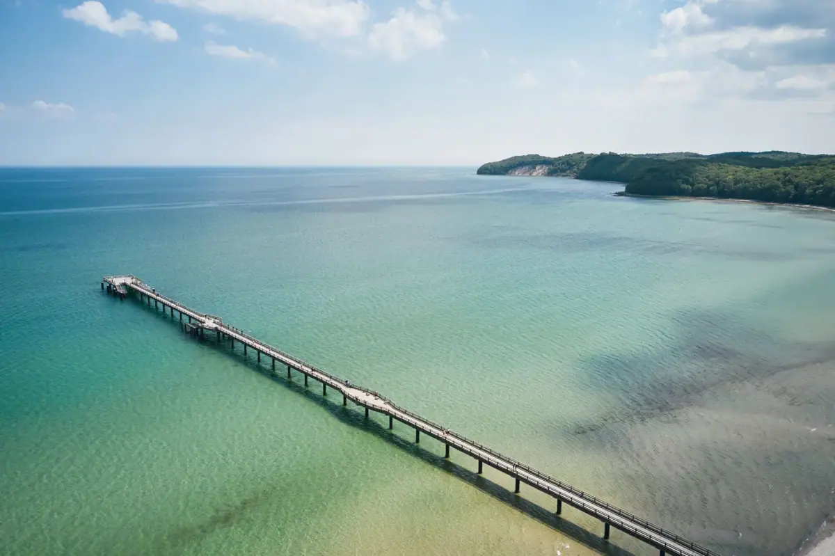Long bridge spanning over a body of water with a cloudy sky.