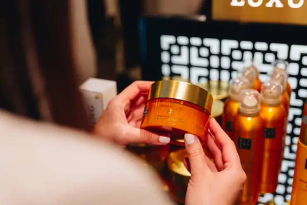 SPA Shop A person holding a jar of cream indoors.