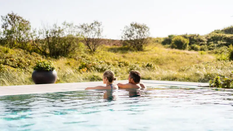 Ein Mann und eine Frau in einem Pool im Freien.