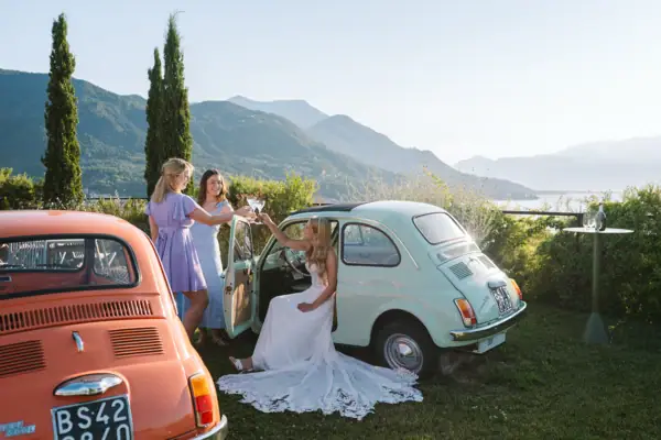 Terrazzo 500 – ein Empfang mit italienischem Charme Hochzeitsgäste und Brautpaar feiern auf der Terrazzo 500 mit Fiat 500 und Blick über den Gardasee.