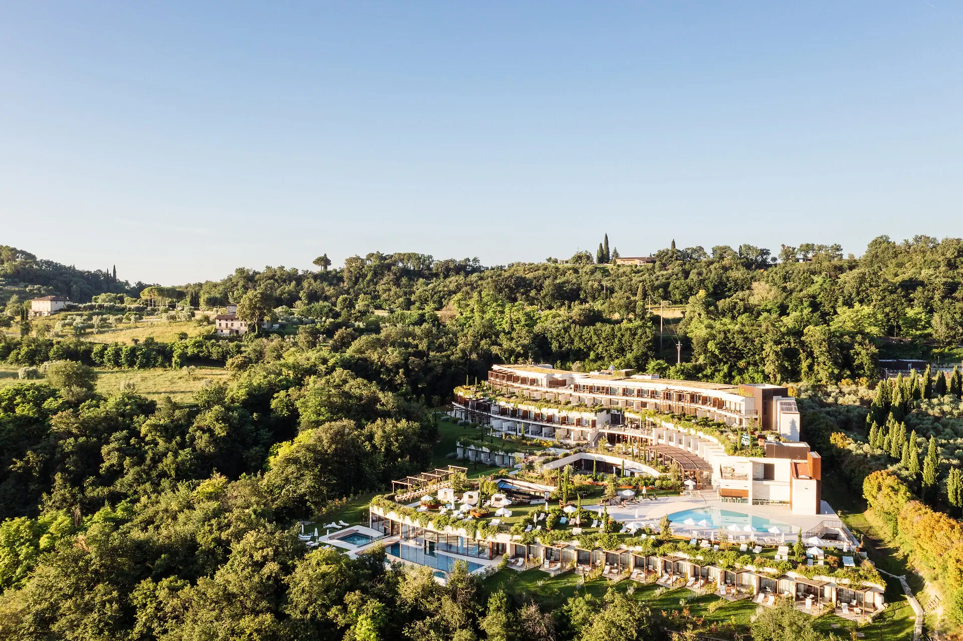 Ein Gebäude mit einem Pool, umgeben von Bäumen.