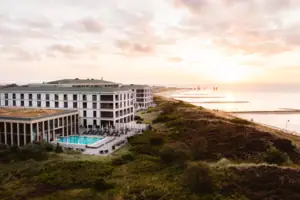 A building with a swimming pool by the water.