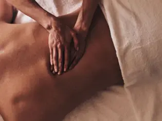 Person receives a back massage in an indoor room.