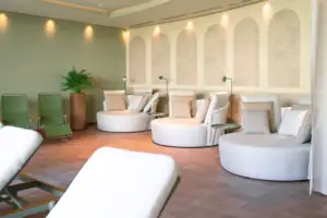 A room with round white chairs and a plant.
