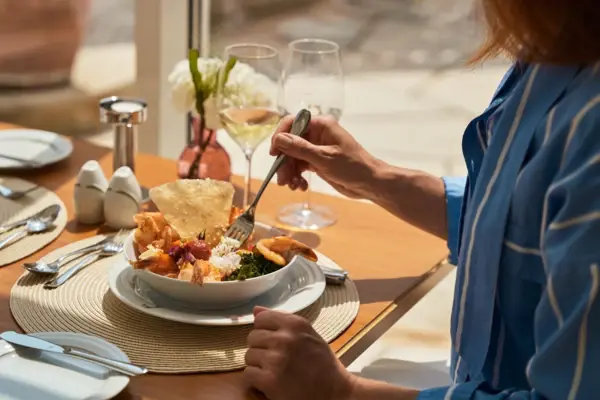 Woman eating a bowl of food.