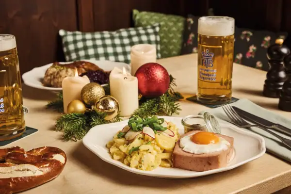 A plate of food with a beer on a table.