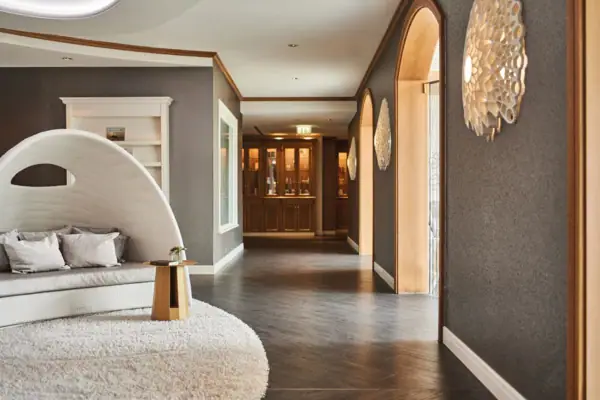 Der Eingang zum Spa Bereich im Kurhaus Binz mit weißem Teppich und rundem Stuhl.